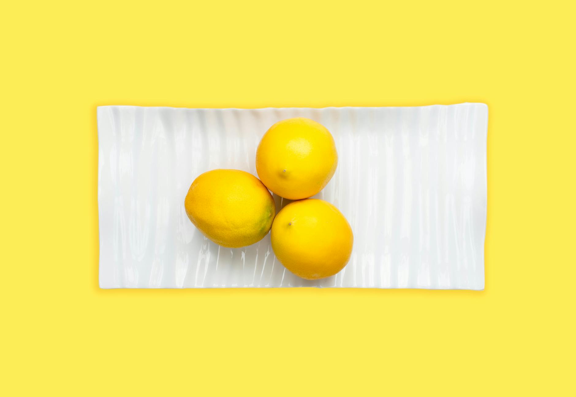 Close-up of fresh lemon halves on a pink background, representing hormonal shifts and renewed sensitivity.
