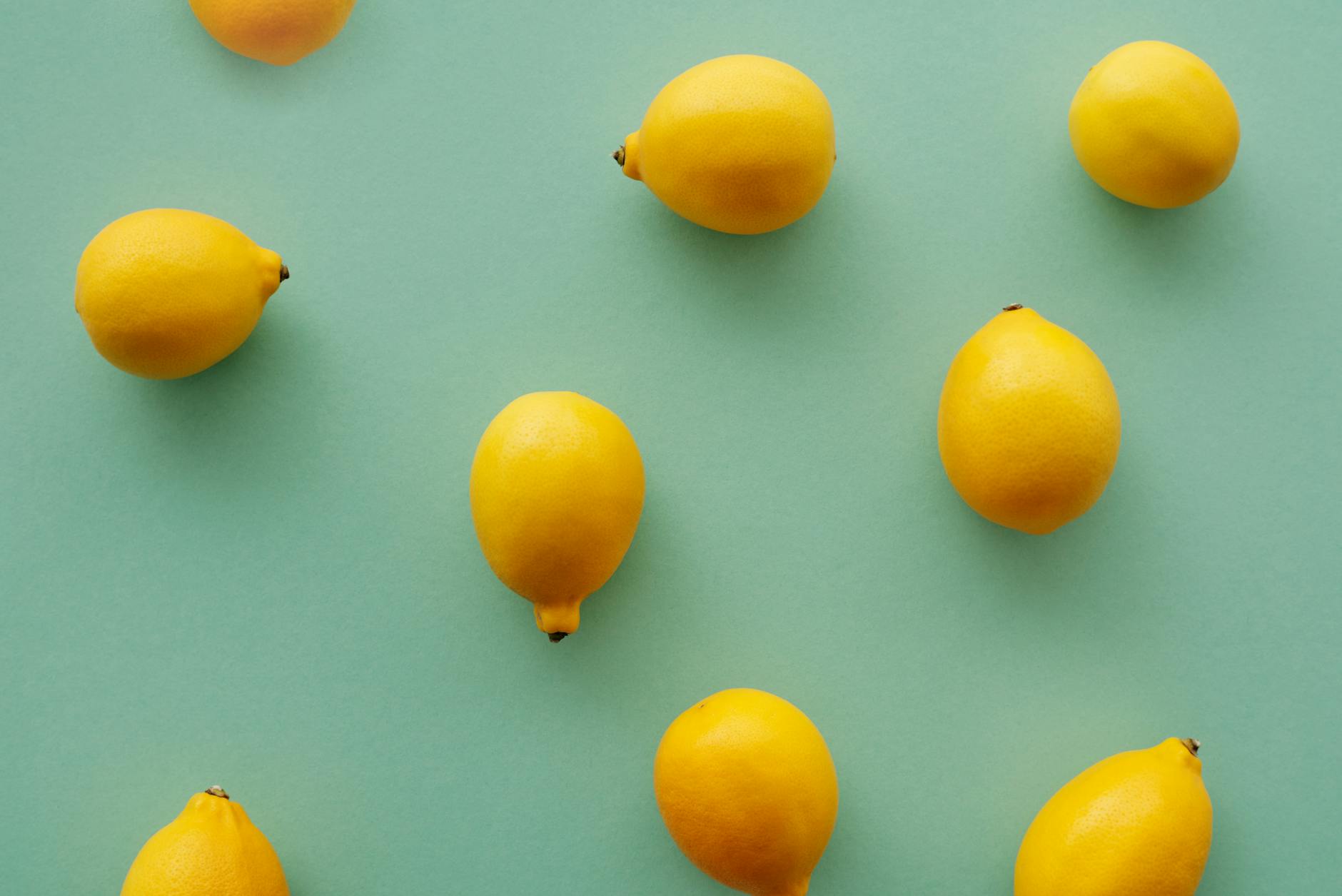 Bright yellow lemons arranged on a pastel green background, symbolizing fresh approaches to rekindling desire.