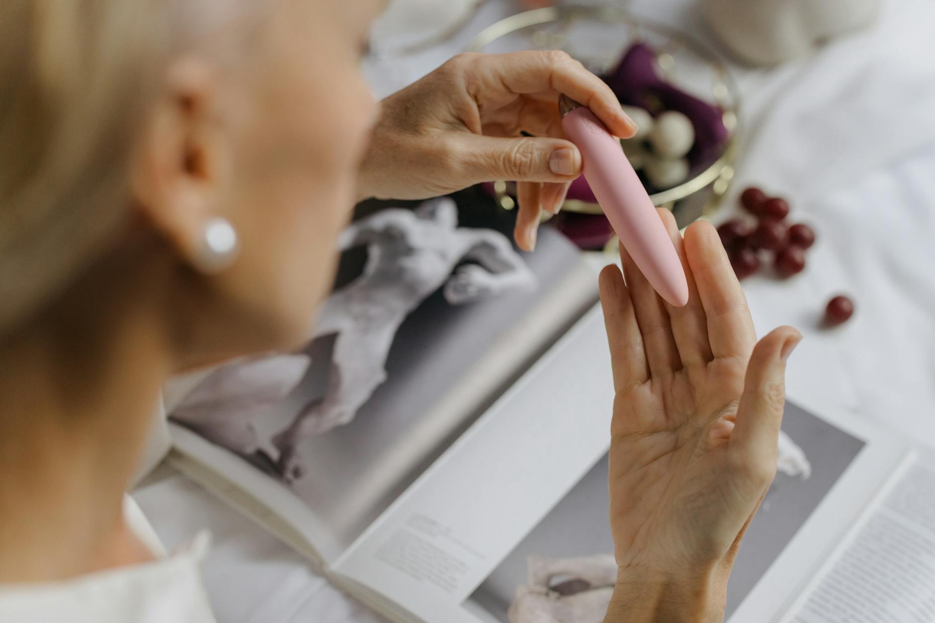 Woman holding blue and pink silicone vibrators, exploring reconnection with intimacy