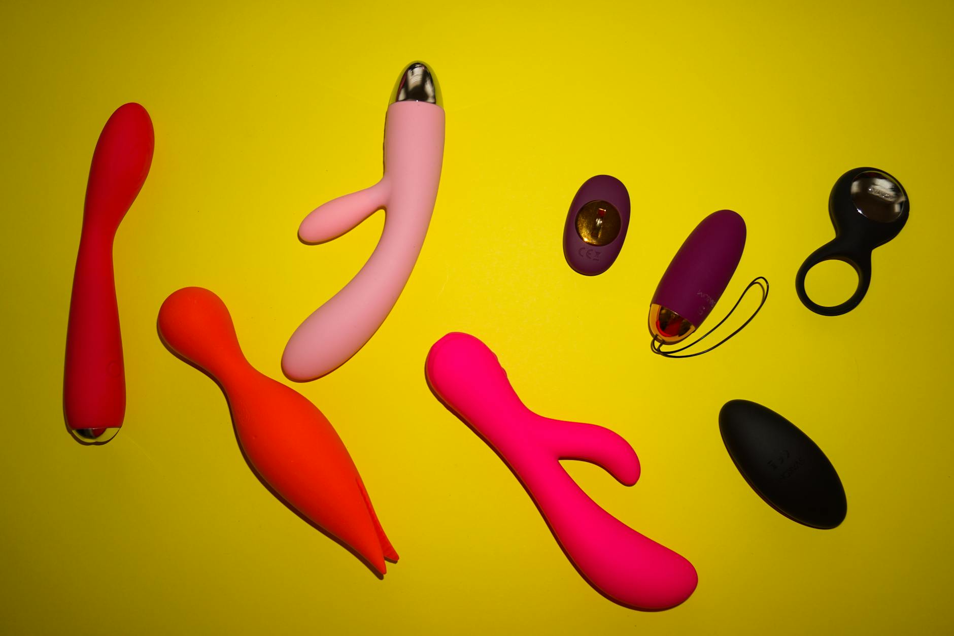 Blue silicone clitoral vibrator held in hand against purple background